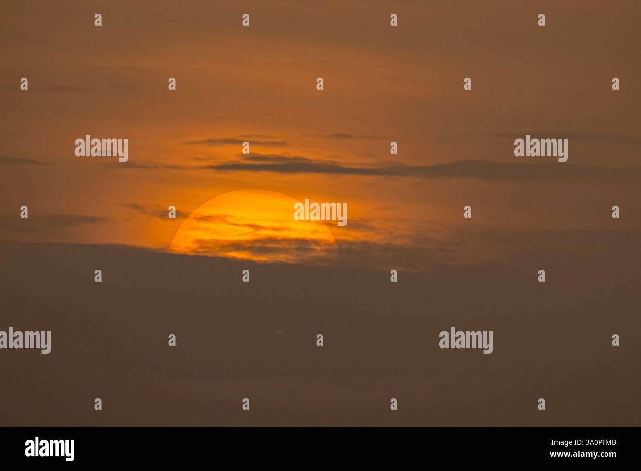 Wunderschöne große Sonne untergeht mitten in der Wolke, isolierte riesige Sonne in der Dämmerung, magische Momente am Himmel Stockfoto