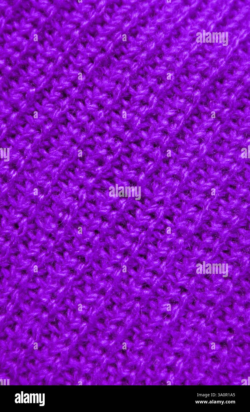 Die Textur des lila gestrickten Wollmaterials in diagonalen Mustern Stockfoto