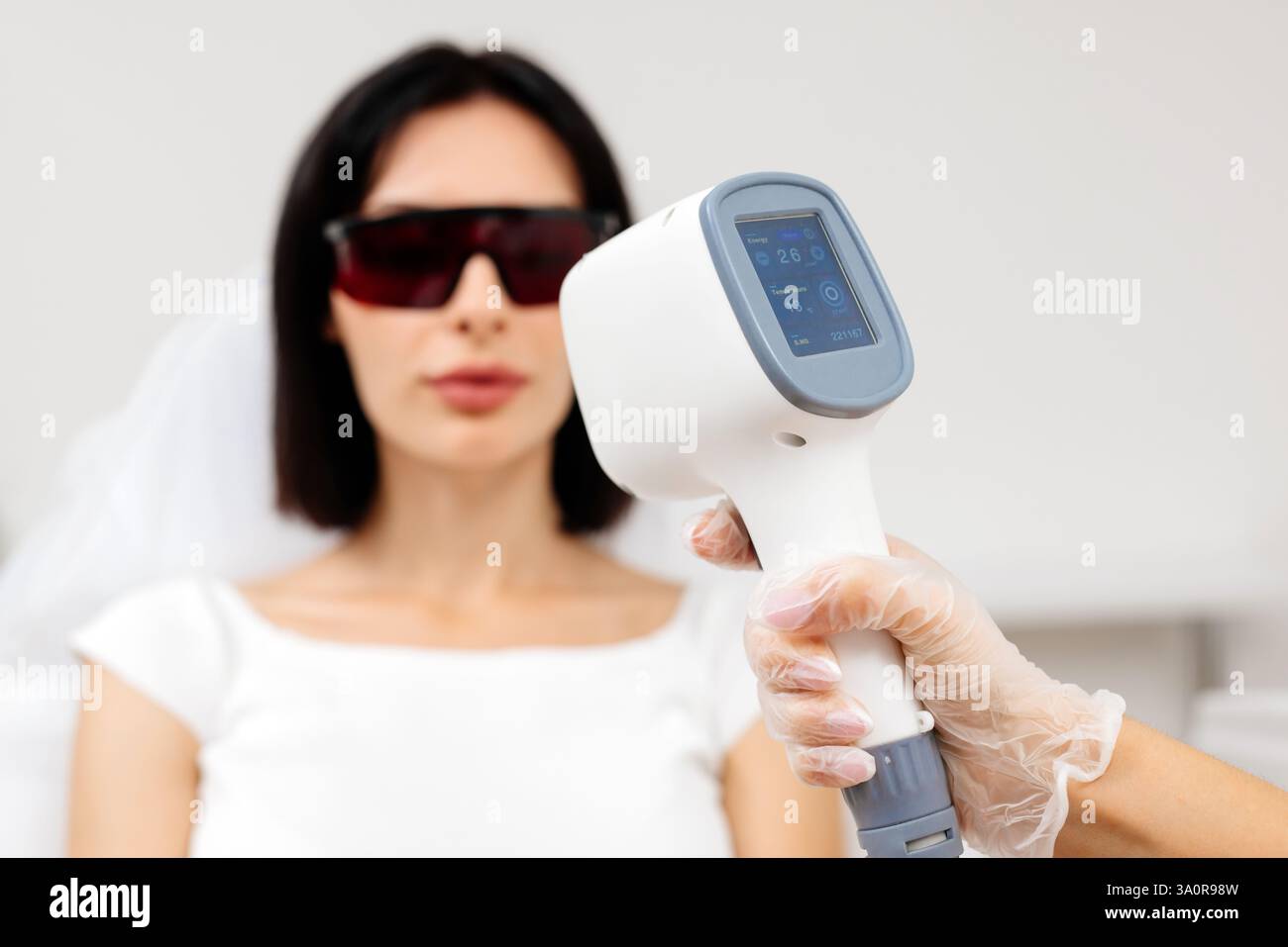 Die Therapeutin/Kosmetikerin führt eine Laserbehandlung auf dem Gesicht einer Frau in einer Schönheitsklinik durch. Nahaufnahme. Das Konzept der Werbung gesund Stockfoto Die Therapeutin/Kosmetikerin führt eine Laserbehandlung auf dem Gesicht einer Frau in einer Schönheitsklinik durch. Nahaufnahme. Das Konzept der Werbung gesund Stockfoto