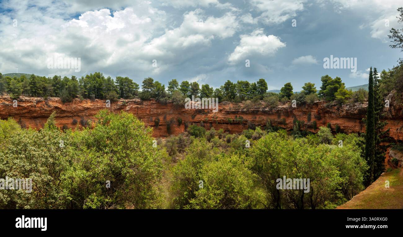 Blick auf die kleine Doline in Argolis, Griechenland, unter bewölktem Himmel, mit leuchtenden Farben und dem einzigartigen geologischen Sinkloch. Stockfoto