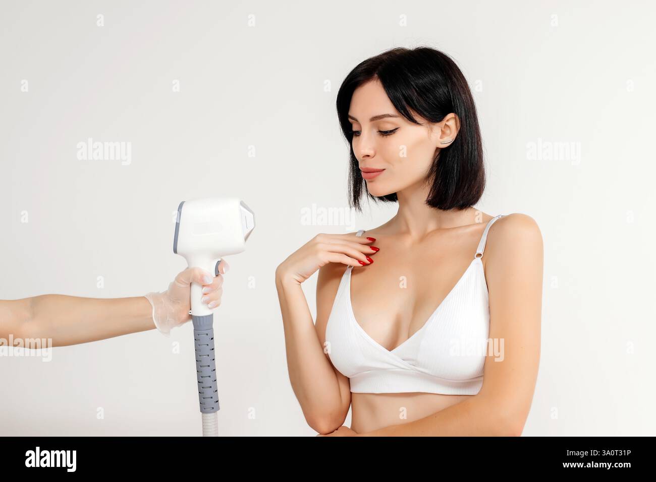 Körperhygiene. Laserhaarentfernung des Körpers. Ein Kosmetiker entfernt Körperhaare junger Frauen. Laserhaarentfernung in einer Kosmetikklinik. Stockfoto Körperhygiene. Laserhaarentfernung des Körpers. Ein Kosmetiker entfernt Körperhaare junger Frauen. Laserhaarentfernung in einer Kosmetikklinik. Stockfoto