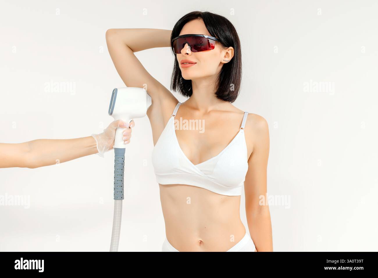 Körperhygiene. Laserhaarentfernung des Körpers. Ein Kosmetiker entfernt Körperhaare junger Frauen. Laserhaarentfernung in einer Kosmetikklinik. Stockfoto Körperhygiene. Laserhaarentfernung des Körpers. Ein Kosmetiker entfernt Körperhaare junger Frauen. Laserhaarentfernung in einer Kosmetikklinik. Stockfoto