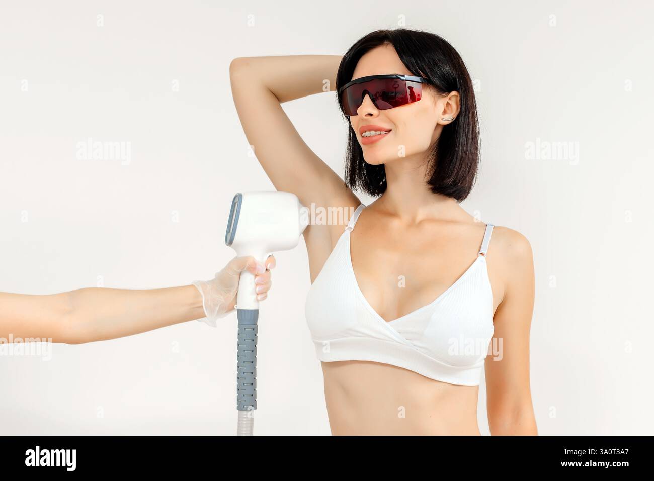 Körperhygiene. Laserhaarentfernung des Körpers. Ein Kosmetiker entfernt Körperhaare junger Frauen. Laserhaarentfernung in einer Kosmetikklinik. Stockfoto Körperhygiene. Laserhaarentfernung des Körpers. Ein Kosmetiker entfernt Körperhaare junger Frauen. Laserhaarentfernung in einer Kosmetikklinik. Stockfoto