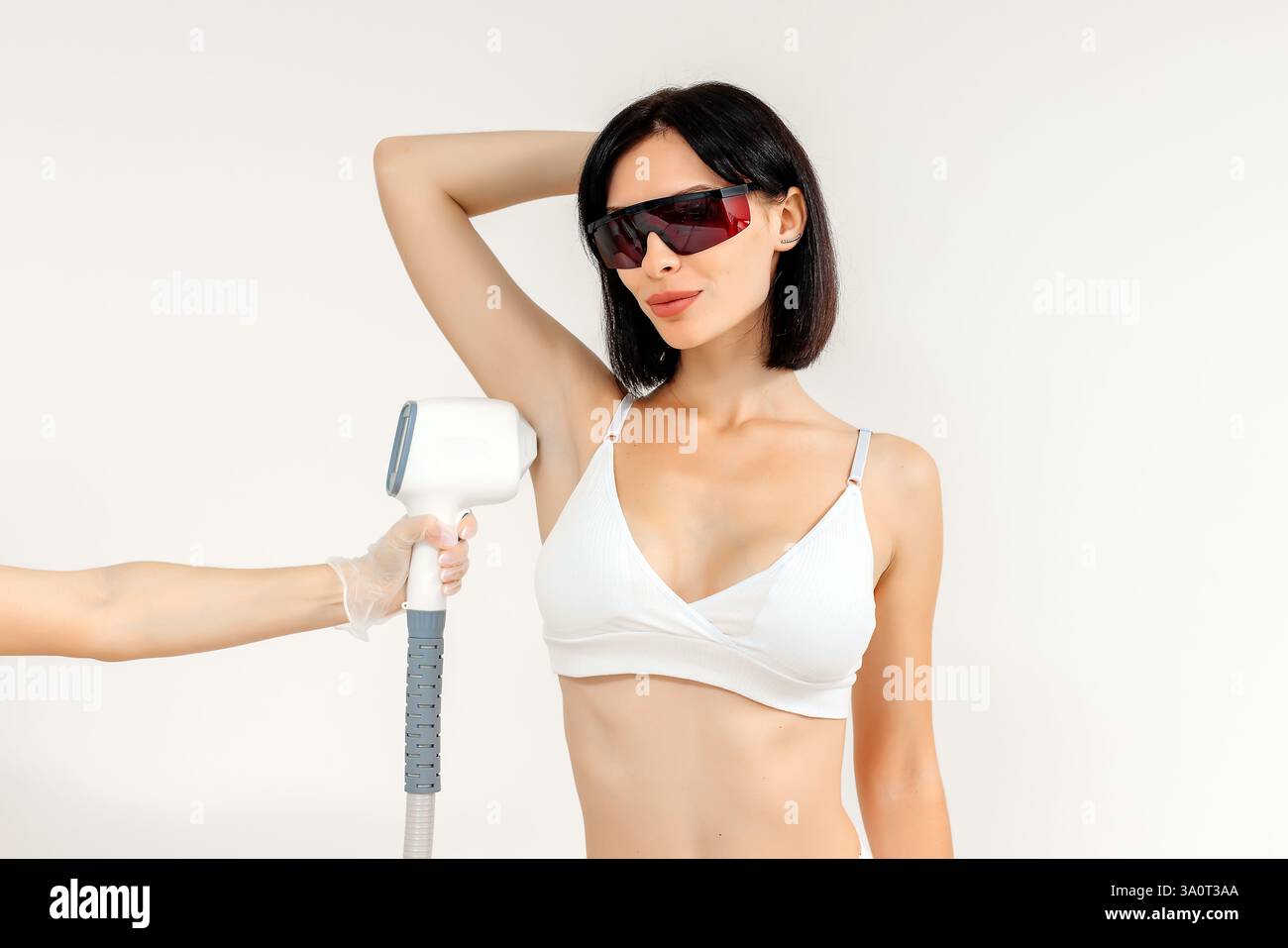 Körperhygiene. Laserhaarentfernung des Körpers. Ein Kosmetiker entfernt Körperhaare junger Frauen. Laserhaarentfernung in einer Kosmetikklinik. Stockfoto Körperhygiene. Laserhaarentfernung des Körpers. Ein Kosmetiker entfernt Körperhaare junger Frauen. Laserhaarentfernung in einer Kosmetikklinik. Stockfoto
