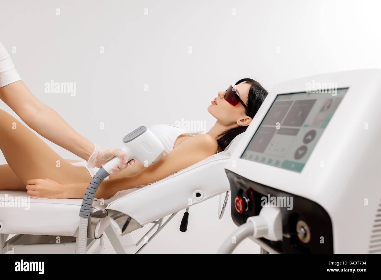 Körperhygiene. Laserhaarentfernung des Körpers. Ein Kosmetiker entfernt Körperhaare junger Frauen. Laserhaarentfernung in einer Kosmetikklinik. Stockfoto Körperhygiene. Laserhaarentfernung des Körpers. Ein Kosmetiker entfernt Körperhaare junger Frauen. Laserhaarentfernung in einer Kosmetikklinik. Stockfoto