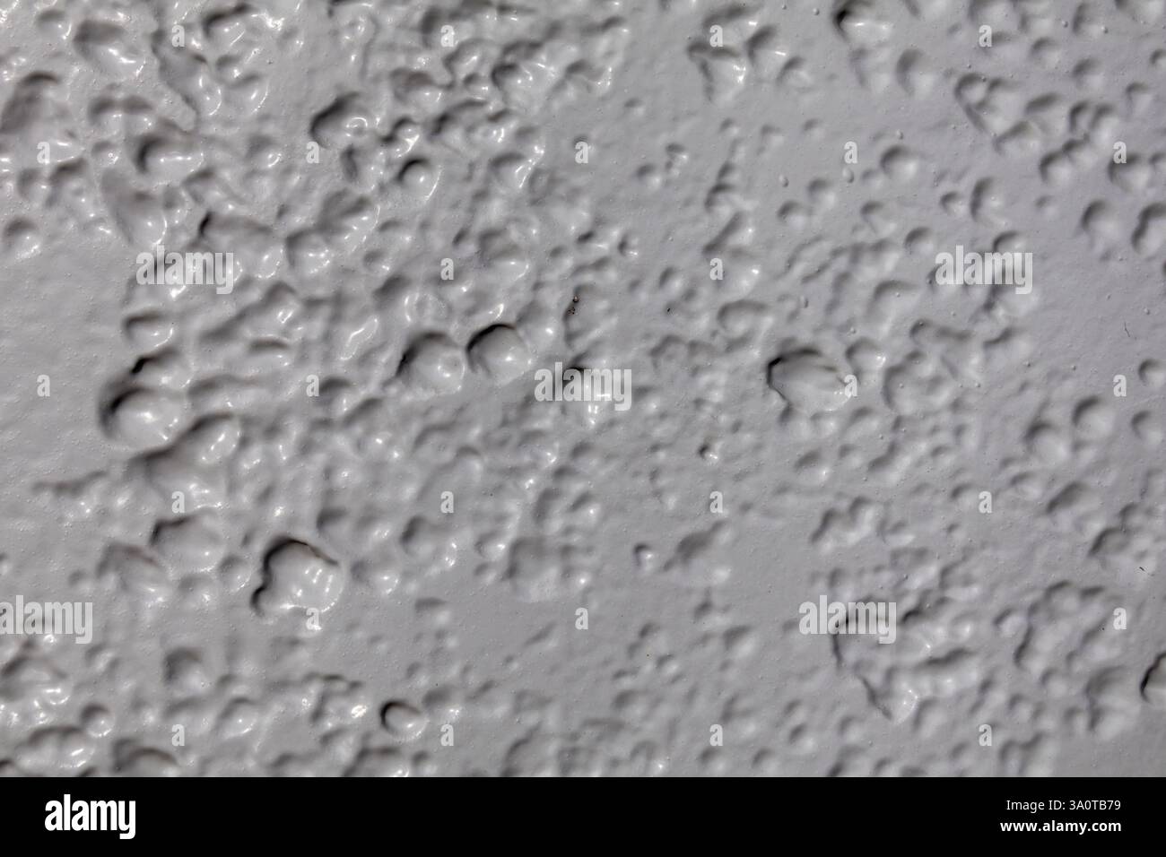 Nahaufnahme aus hellgrau lackiertem Metall, das Oberflächenstrukturen mit subtilen Farbvariationen hervorhebt. Ideal für Hintergrund und Textur Stockfoto