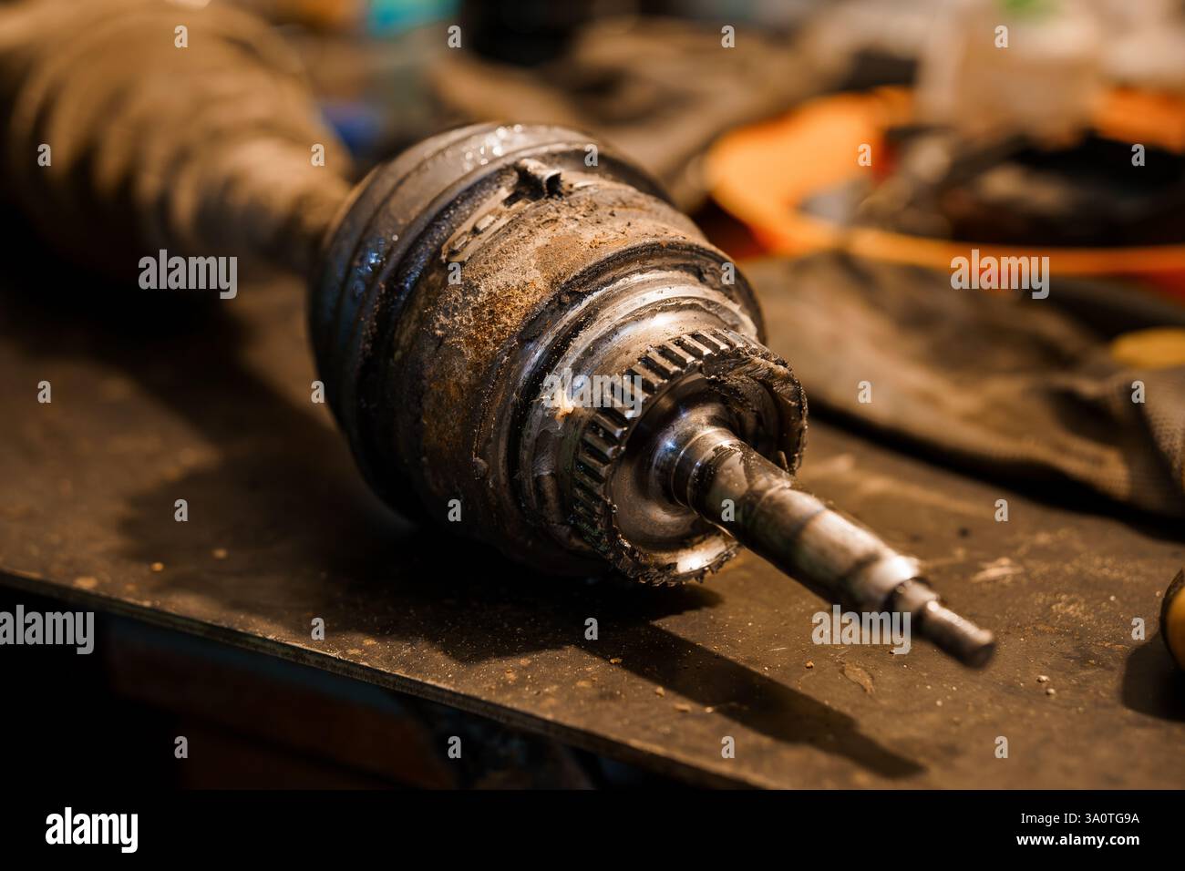 Detaillierte Nahaufnahme eines beschädigten Kfz-Gleichlaufgelenks auf einer Werkbank. Stockfoto