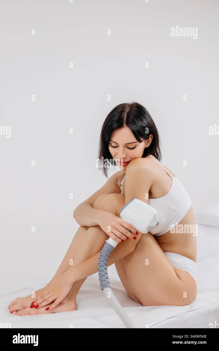 Körperhygiene. Laserhaarentfernung des Körpers. Ein Kosmetiker entfernt Körperhaare junger Frauen. Laserhaarentfernung in einer Kosmetikklinik. Stockfoto Körperhygiene. Laserhaarentfernung des Körpers. Ein Kosmetiker entfernt Körperhaare junger Frauen. Laserhaarentfernung in einer Kosmetikklinik. Stockfoto