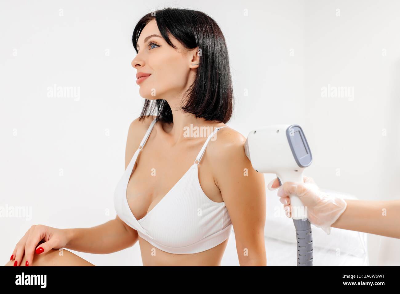 Körperhygiene. Laserhaarentfernung des Körpers. Ein Kosmetiker entfernt Körperhaare junger Frauen. Laserhaarentfernung in einer Kosmetikklinik. Stockfoto Körperhygiene. Laserhaarentfernung des Körpers. Ein Kosmetiker entfernt Körperhaare junger Frauen. Laserhaarentfernung in einer Kosmetikklinik. Stockfoto
