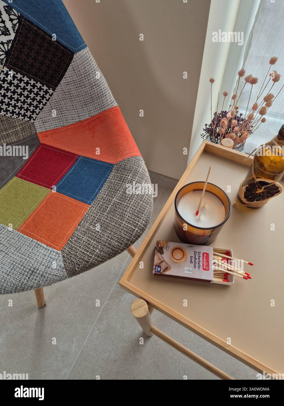 Heller Stuhl, Tisch mit Kerze und Streichhölzern Stockfoto