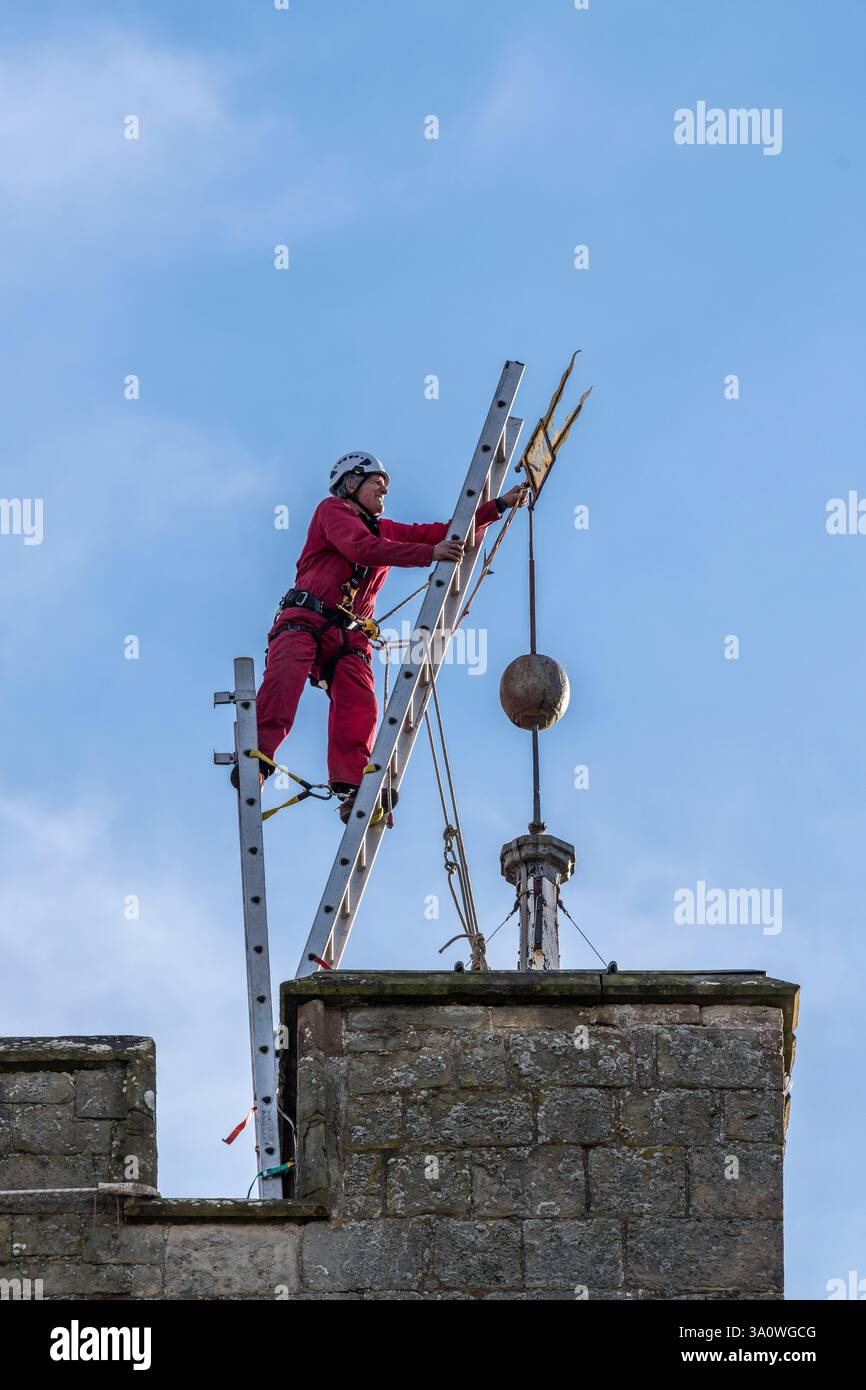 Der 77 Jahre alte Turmjäger Chris Milford balancierte auf dem mittelalterlichen Turm der St. Andrew's Church in Presteigne, Powys, und entfernte die Wetterfahne für Reparaturen und Regilding (Wales, Großbritannien). Chris arbeitet für WallWalkers Ltd. Aus Bristol Stockfoto