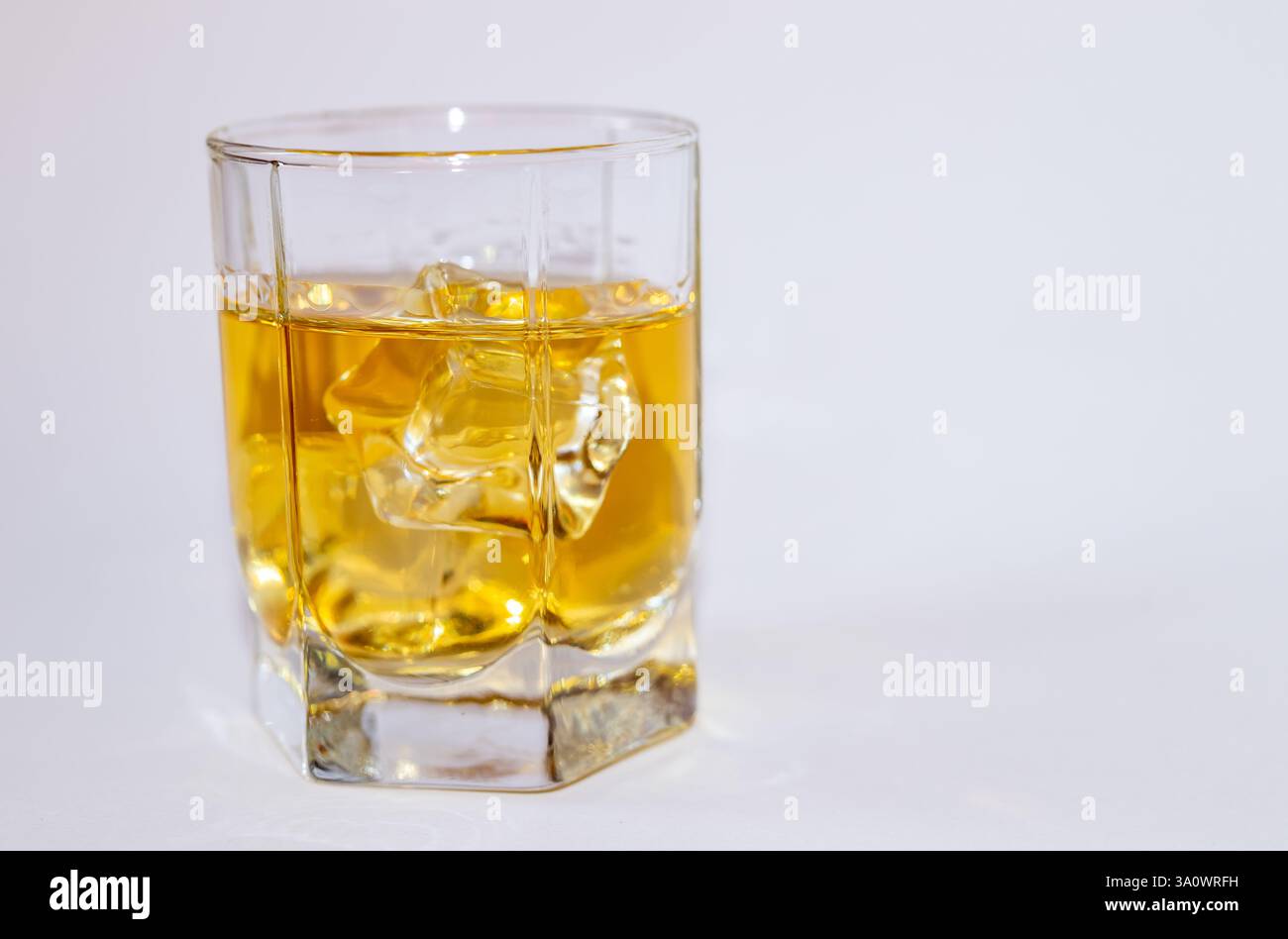 Goldener Whiskey mit Eis in einem Kristallglas Stockfoto
