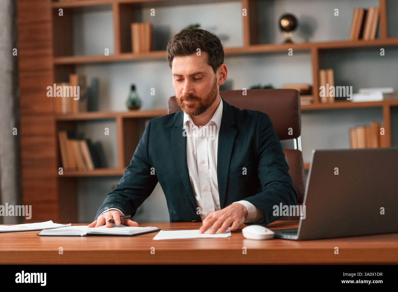 Geschäftsmann in formeller Kleidung arbeitet drinnen. Stockfoto