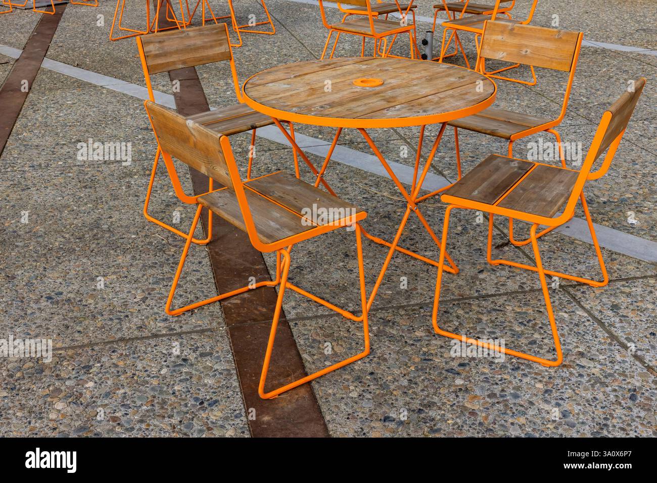 Orange Stühle werfen am letzten Nachmittag Schatten im Waterfront Park in Seattle, Washington State, USA Stockfoto