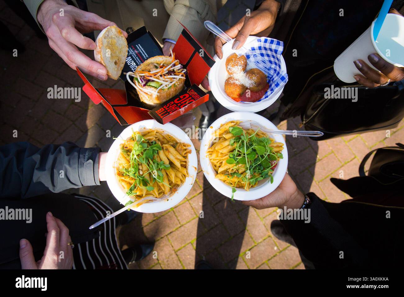 Street Food-Leute teilen sich Pasta, Sandwiches und Aranini. Stockfoto