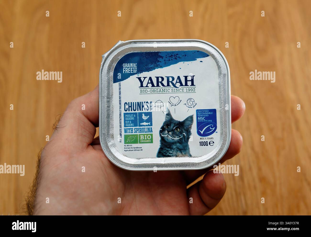 Paris, Frankreich - 12. Februar 2025: Hand in der Hand einen Behälter mit Bio-Katzenfutter von Yarrah mit nachhaltigen Zutaten wie Geflügel, Hering und Spirul Stockfoto
