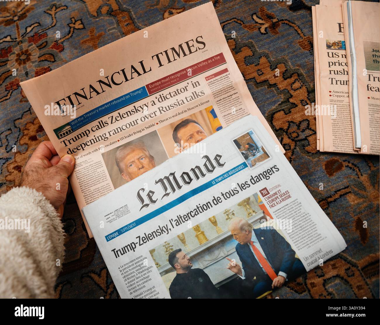 Paris, Frankreich - 4. März 2025: Eine Person untersucht zwei Zeitungen, die Financial Times und Le Monde, die jeweils Schlagzeilen über Trumps umstrittenen remar zeigen Stockfoto