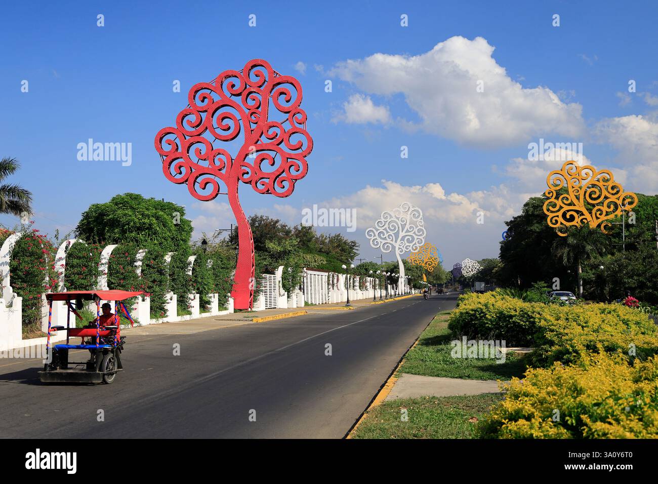 Ein Dreiradtaxi auf gigantischen LED-Lichtmetallbäumen (Bäume des Lebens) schmückte die Paseo Xolotan Straße in der Nähe der Uferpromenade des Managua-Sees. Managua. Nicaragua Stockfoto