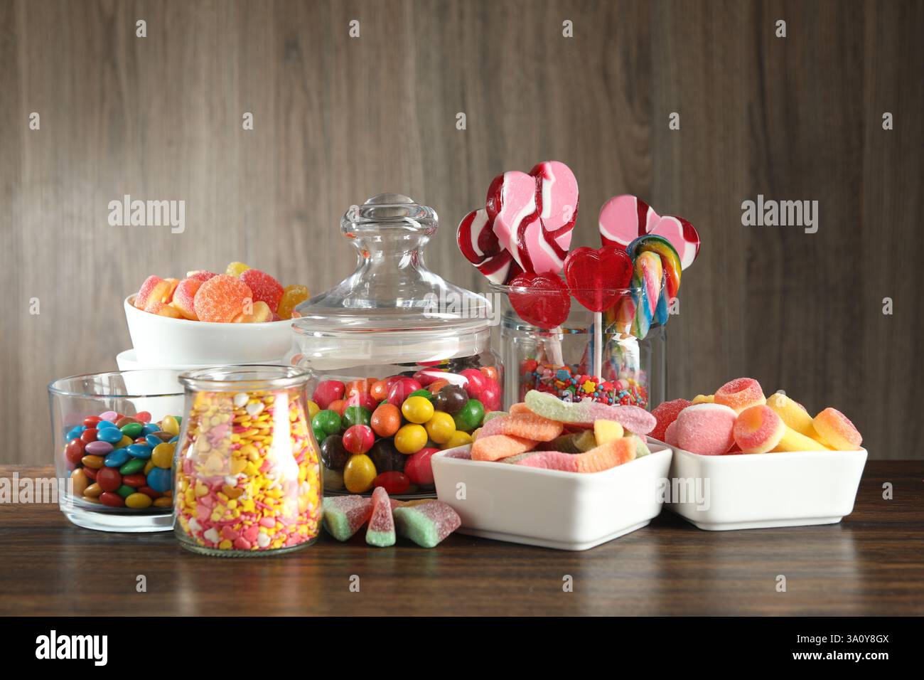 Schokoriegel. Viele verschiedene leckere Süßigkeiten auf Holztisch Stockfoto