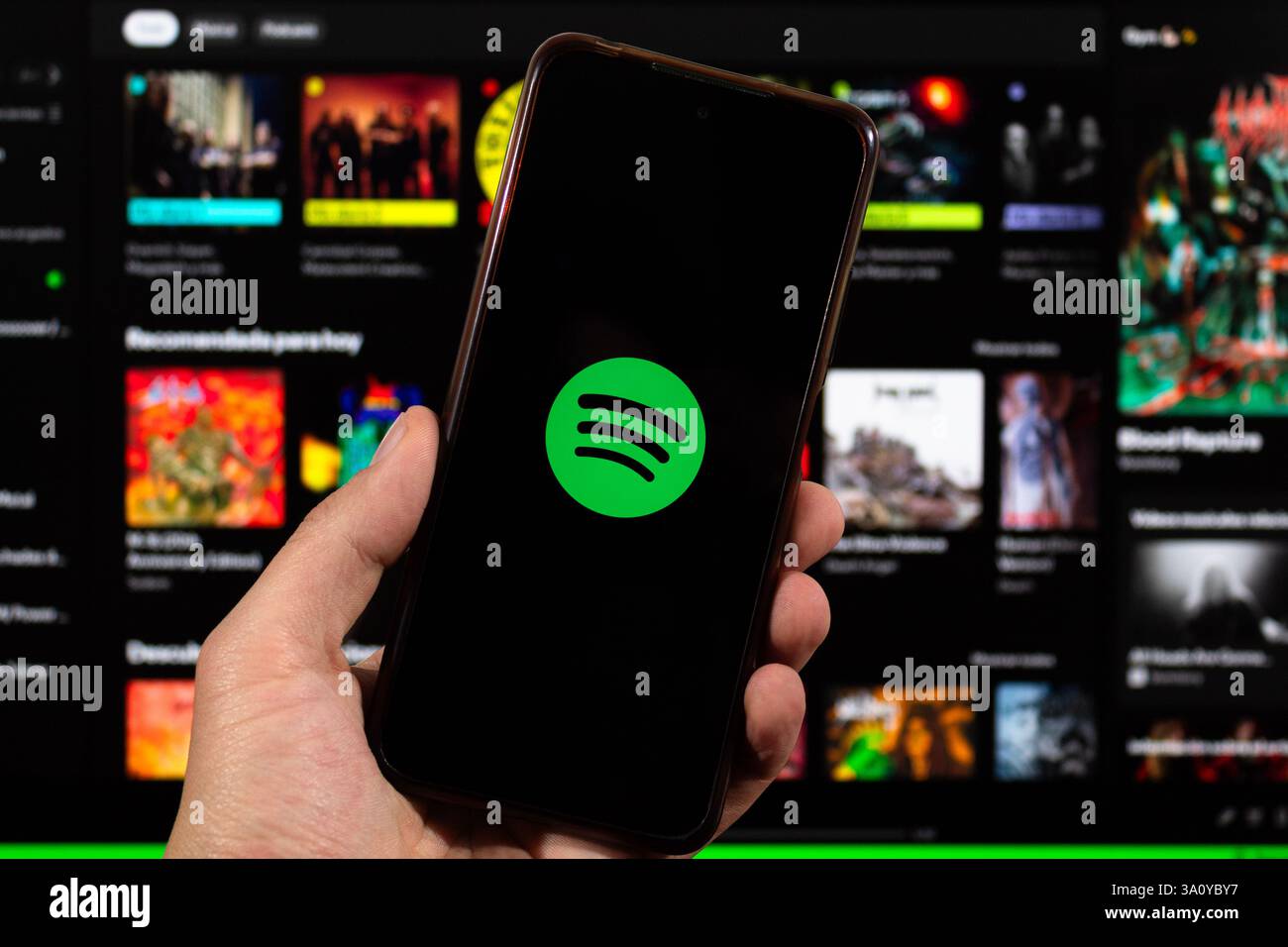 BOGOTA, KOLUMBIEN - 05. MÄRZ 2025 ein Smartphone mit spotify App-Symbol über unscharfer spotify-Oberfläche im Hintergrund Stockfoto