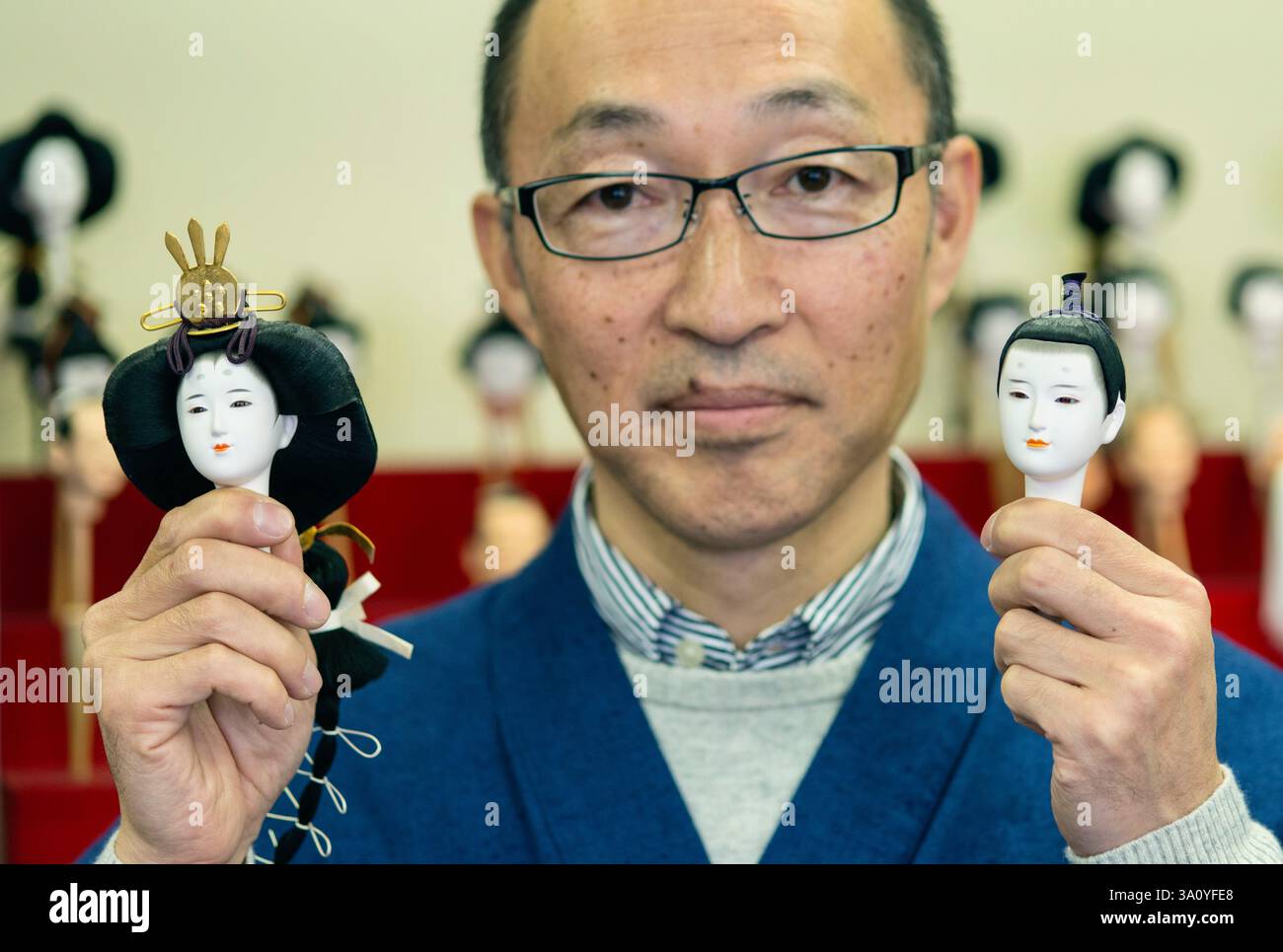 Hiroshi Omamiuda hält die Köpfe zweier Iwatsuki Ningyo Dolls, die von Taisei Ningyo in Iwatsuki, Präfektur Saitama, Japan, hergestellt wurden Stockfoto