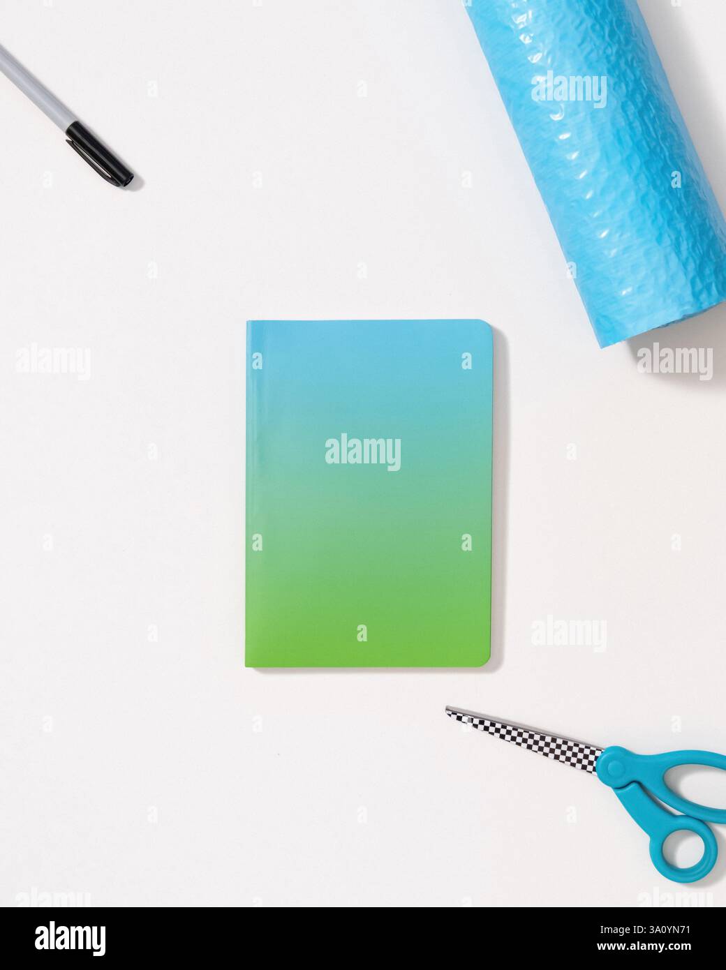 Buchmockup-Vorlage auf weißem Hintergrund mit Schere, Marker, Verpackungsfolie und Kopierraum Stockfoto