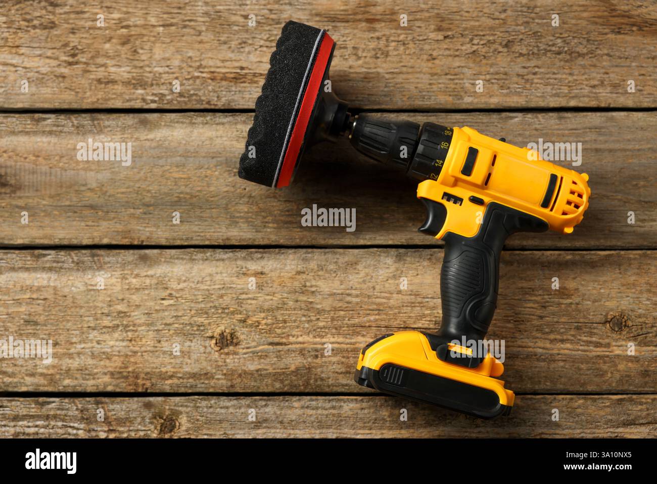 Elektrischer Schraubendreher mit polsterpolster auf Holztisch, Draufsicht. Leerzeichen für Text Stockfoto