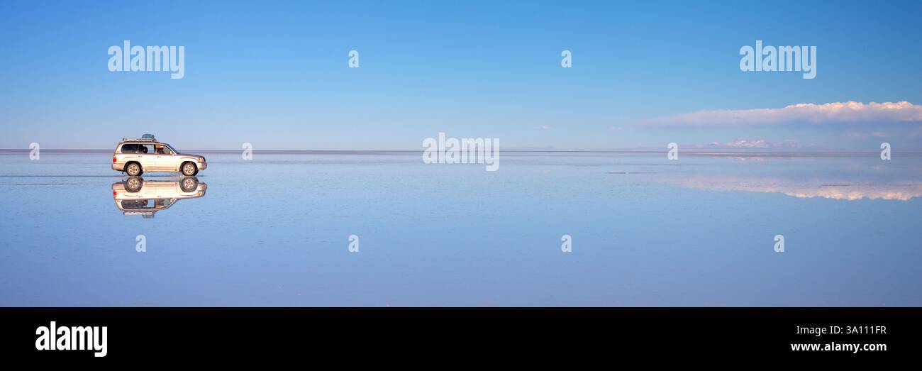 Spiegeleffekt und Reflexionen eines Geländewagens in Salar de Uyuni (Uyuni Salinen), Potosi Panorama, Bolivien Web Banner, Südamerika Stockfoto