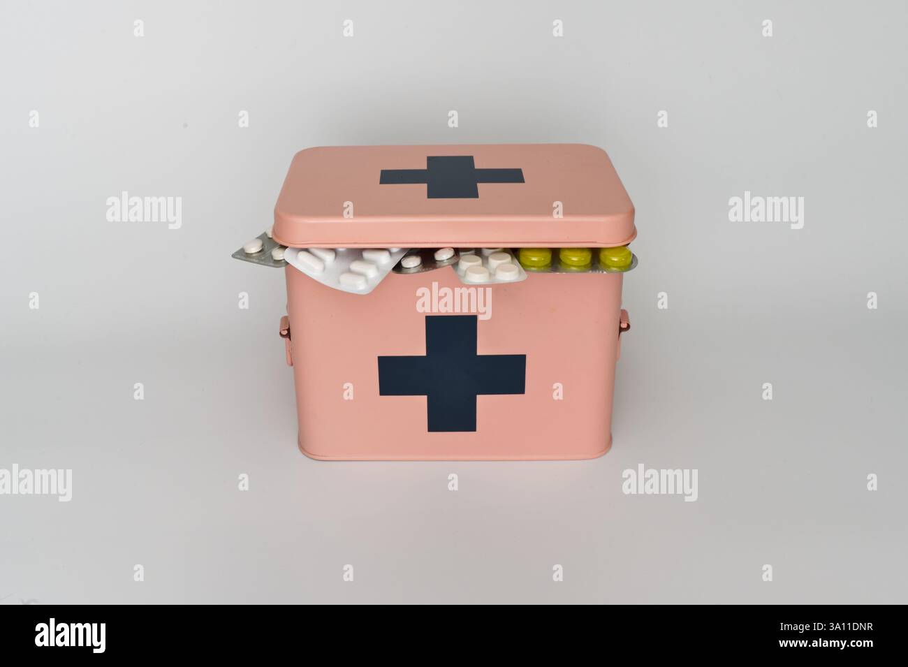 Ein rosafarbener erste-Hilfe-Kasten mit einem schwarzen Kreuz ist geöffnet Stockfoto