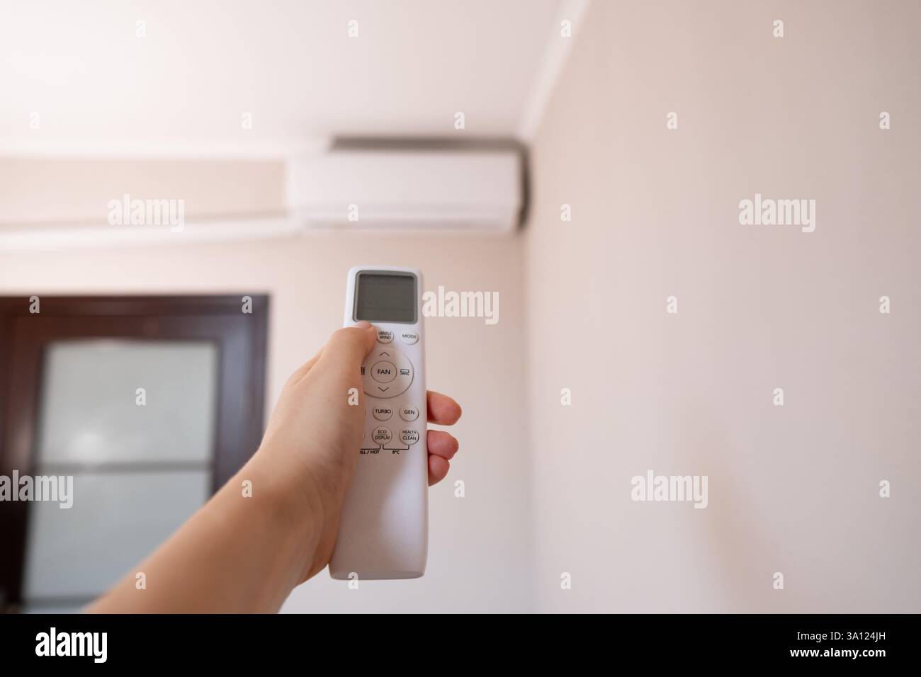 Smart Home in Aktion: Frau steuert Beleuchtung und Geräte per Fernbedienung und schafft perfekte Bedingungen in ihrem Zuhause. Stockfoto