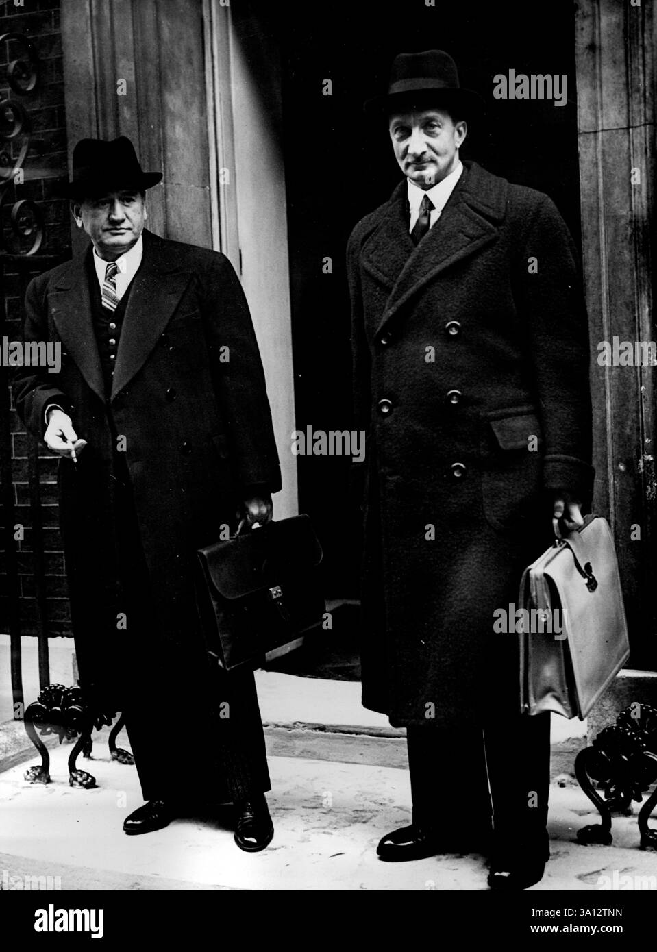 Französischer Premierminister und Außenminister in der Downing Street zum Krisengespräch -- M. Edouard Daladier (links) und M. Georges Bonnet in der Downing Street 10. Der französische Premierminister M. Daladiar und der Außenminister M. Georges Bonnets gingen nach der Landung in die Downing Street. In Croydon mit einem Sonderflugzeug von Paris für die Gespräche mit Neville Chamberlain, in denen der britische Premierminister über sein Gespräch mit Herrn Hitler berichten wird. Kabinettsminister waren anwesend. September 1938. Stockfoto
