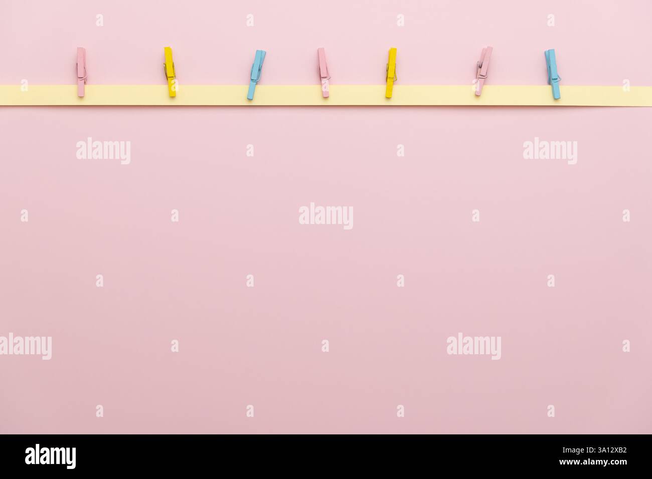 Pastellfarbene Kleiderschränke auf Papierstreifen auf weichem rosa Hintergrund, perfekt für Frühlings-, Ostern- oder minimalistische Dekorationsprojekte. Scrapbooking, Stockfoto