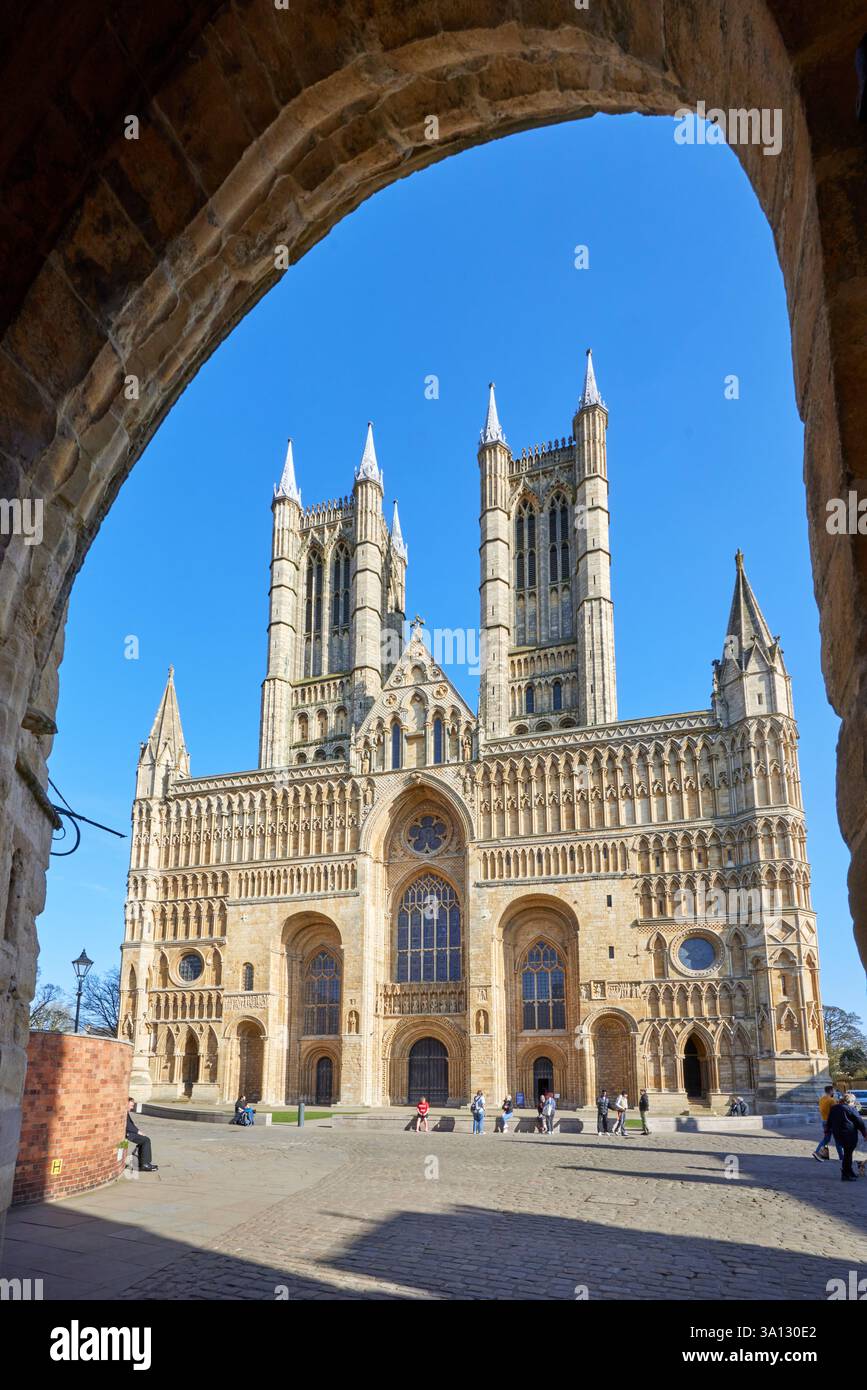 Die Westfront der Lincoln Cathedral ist eine große mittelalterliche Fassade mit komplizierter gotischer Architektur, hohen Türmen und großen Bogengängen. Stockfoto