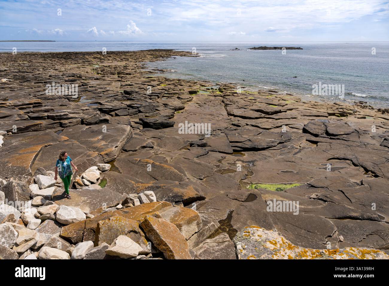 Frankreich, Finistère, Iroise Sea, Molene Island, Christine Demeure, die während ihres täglichen Spaziergangs an der wilden Westküste, dem Ufer von Flat Stones, das einzige Lebensmittelgeschäft auf der Insel verwaltet Stockfoto
