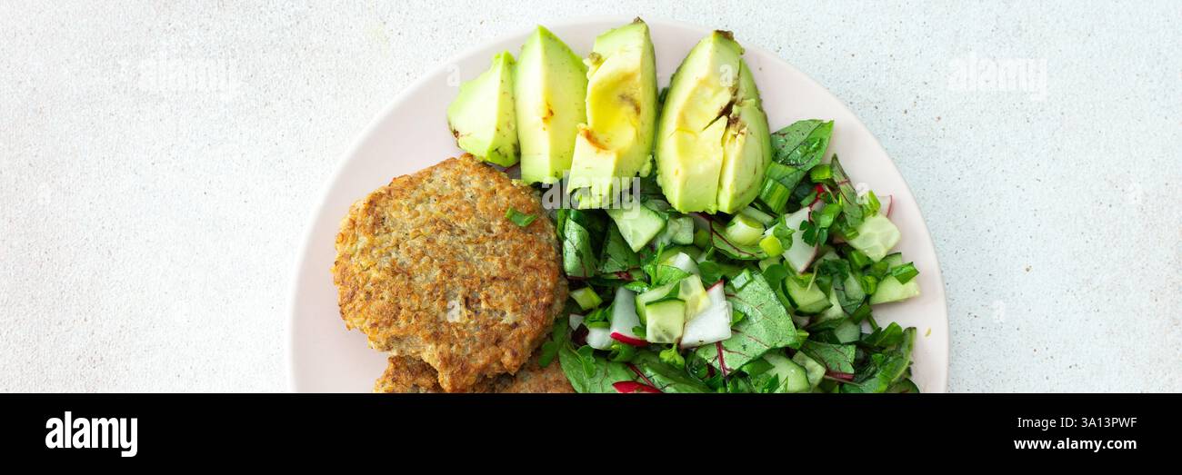 Quinoa Schnitzel und gemischter Salat mit Avocado und Radieschen, Kiwi und Wasser mit Zitrone, köstliches herzhaftes Frühstück, veganes Lunch Teller Banner Stockfoto