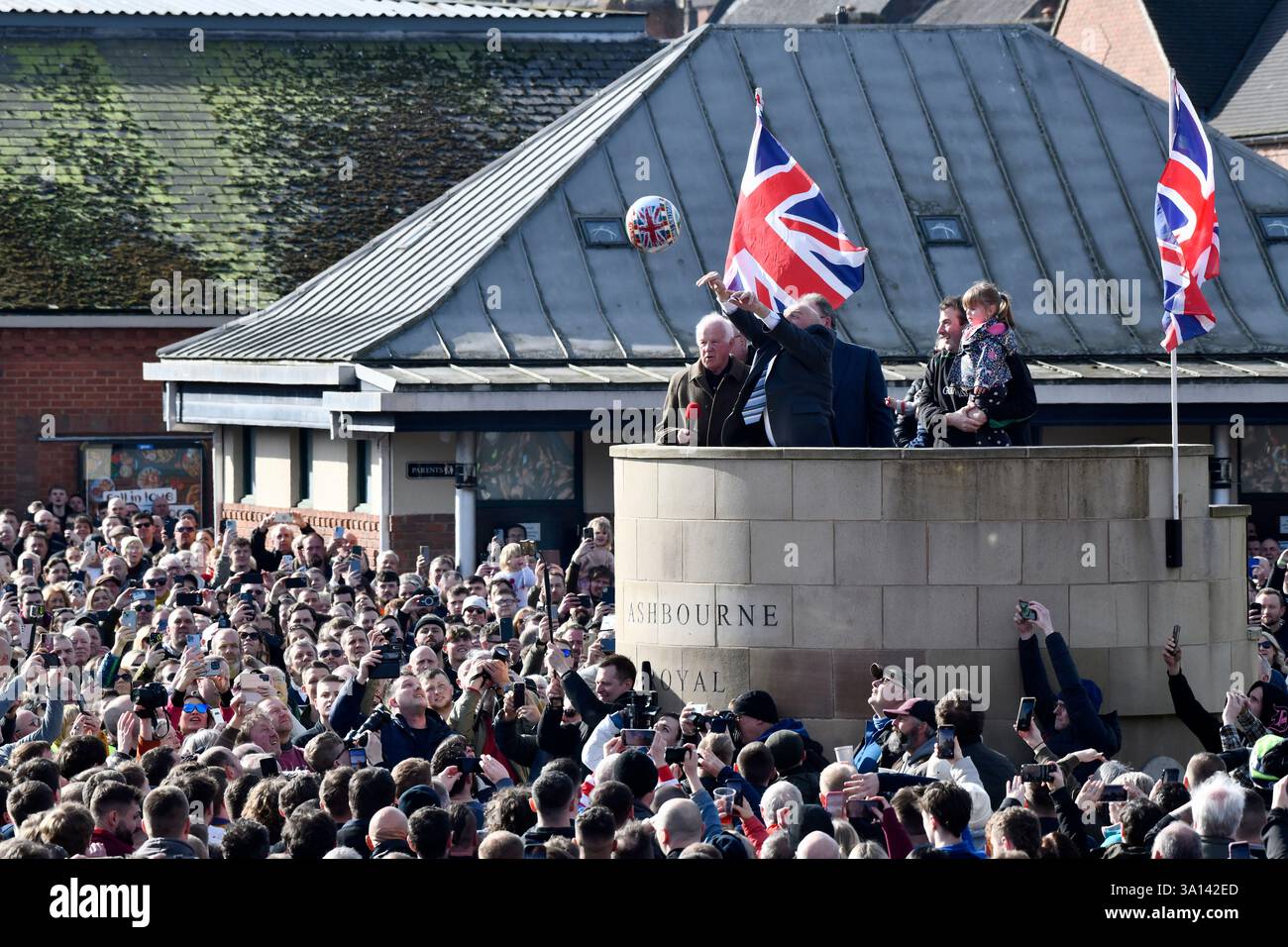 Ashbourne Royal Shrovetide altes Ballspiel mit dem lokalen Bauern David Bott, der den Ball auf dem Sockel der Innenstadt dreht. Stockfoto