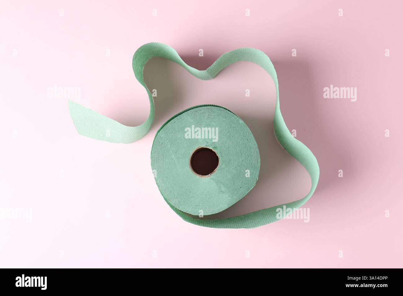 Grüne Toilettenpapierrolle auf hellrosa Hintergrund, Draufsicht Stockfoto