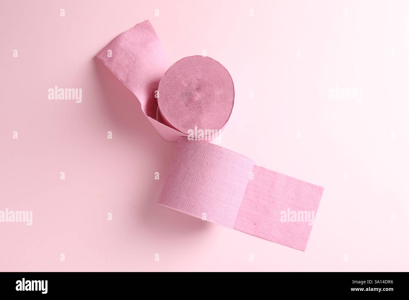 Farbige Toilettenpapierrollen auf hellrosa Hintergrund, Draufsicht Stockfoto