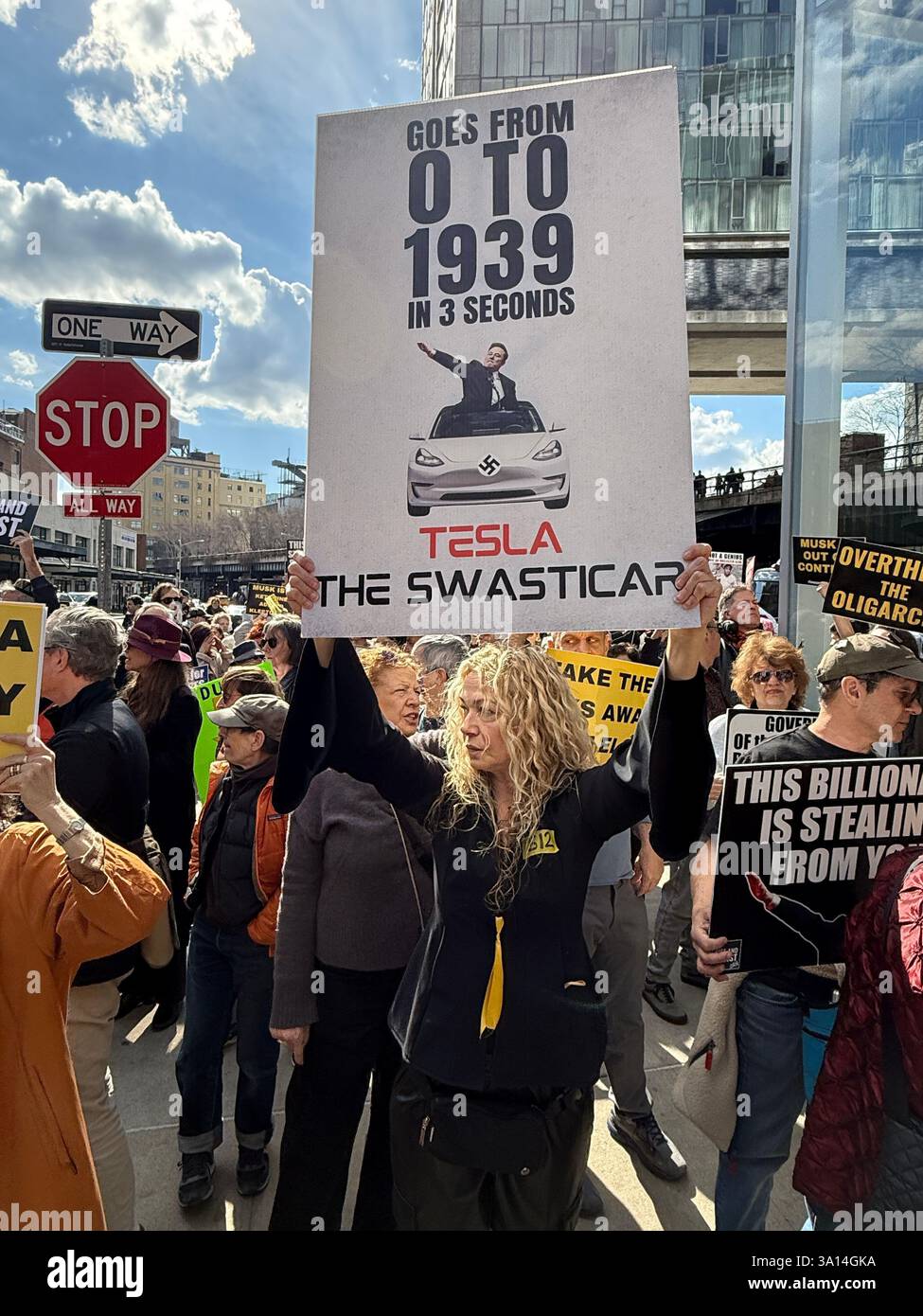 Demonstranten vor einem Tesla-Händler in New York City bekundeten ihre Verachtung dafür, dass Elon Musks DOGE-Kettensäge von Bundesjobs abgeschnitten hat, und im Allgemeinen die Handlungen und viele der Befehle von Präsident Donald Trump. Stockfoto
