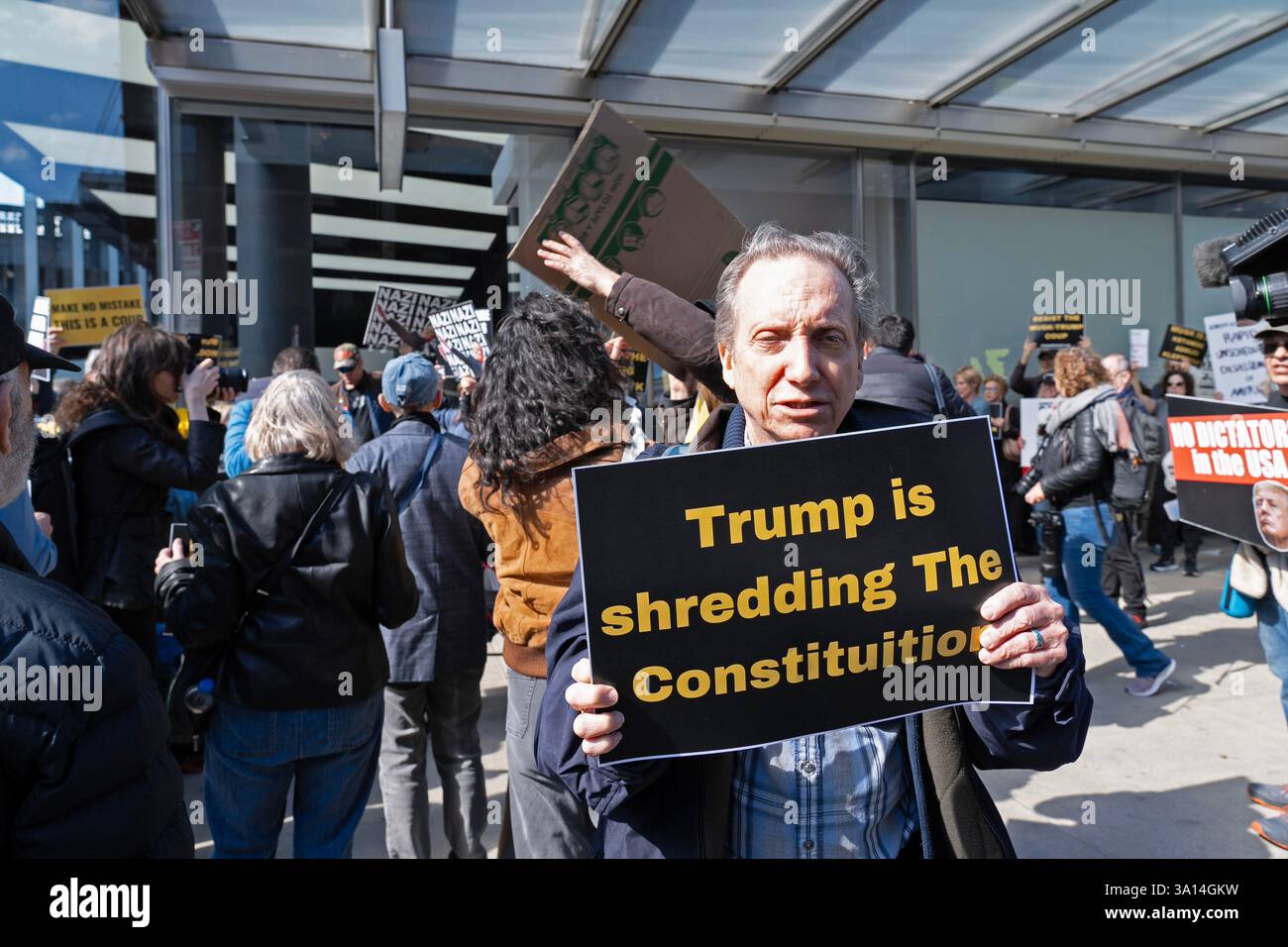 Demonstranten vor einem Tesla-Händler in New York City bekundeten ihre Verachtung dafür, dass Elon Musks DOGE-Kettensäge von Bundesjobs abgeschnitten hat, und im Allgemeinen die Handlungen und viele der Befehle von Präsident Donald Trump. Stockfoto