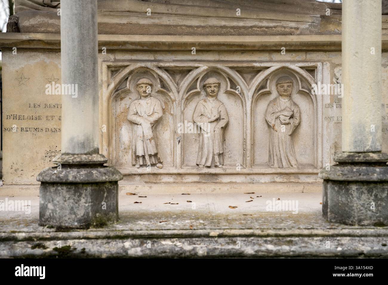 Komplizierte Steinschnitzereien historischer Figuren in einem antiken Bogengang in einem ruhigen Park unter weichem Tageslicht Stockfoto