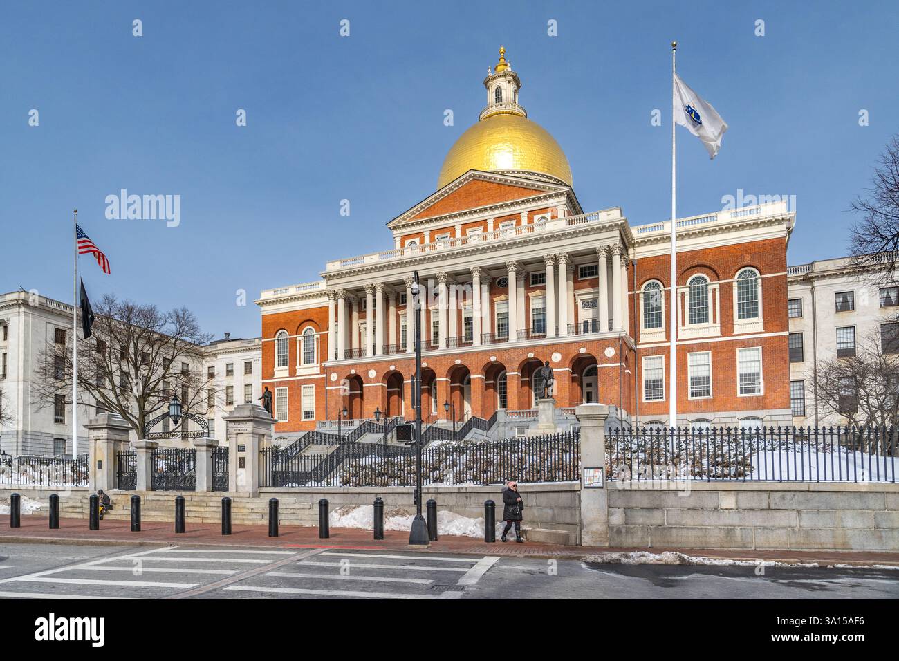 Boston, MA, USA - 11. Februar 2025 - Eine Frau, die an einem klaren Wintertag vor dem Massachusetts State House spaziert Stockfoto