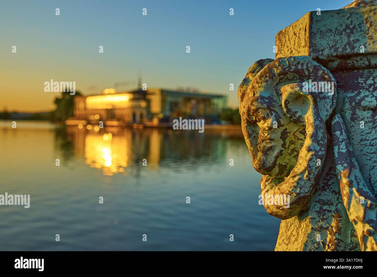 Skulptur de tête de bélier en Bronze vert-de-gris devant le lac et l'Architecture moderne d'Enghien-les-Bains, Frankreich. Contraste Art Ancien et Modern Stockfoto