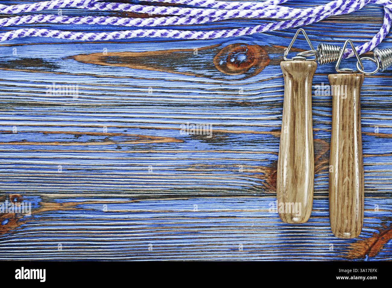 Fitness-Sprungseil auf blauem Vintage-Holzbrett Stockfoto