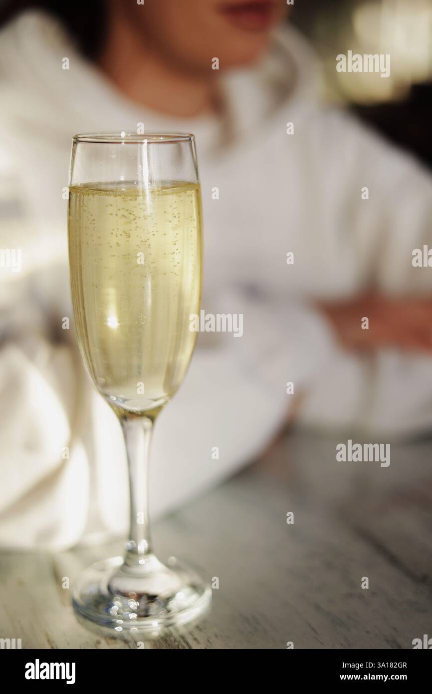Ein Glas Champagner auf dem Tisch spielt mit Blasen. Cocktails und Getränke in einem Restaurant. Date mit einem Mädchen Stockfoto