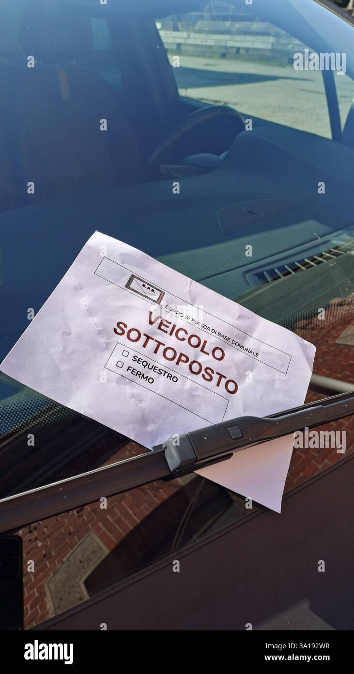 Behördliche Beschlagnahme des Fahrzeugs, des Fahrzeugs, das beschlagnahmt oder beschlagnahmt wird. Blatt Papier mit italienischer Schrift unter dem Scheibenwischer. Stockfoto Behördliche Beschlagnahme des Fahrzeugs, des Fahrzeugs, das beschlagnahmt oder beschlagnahmt wird. Blatt Papier mit italienischer Schrift unter dem Scheibenwischer. Stockfoto