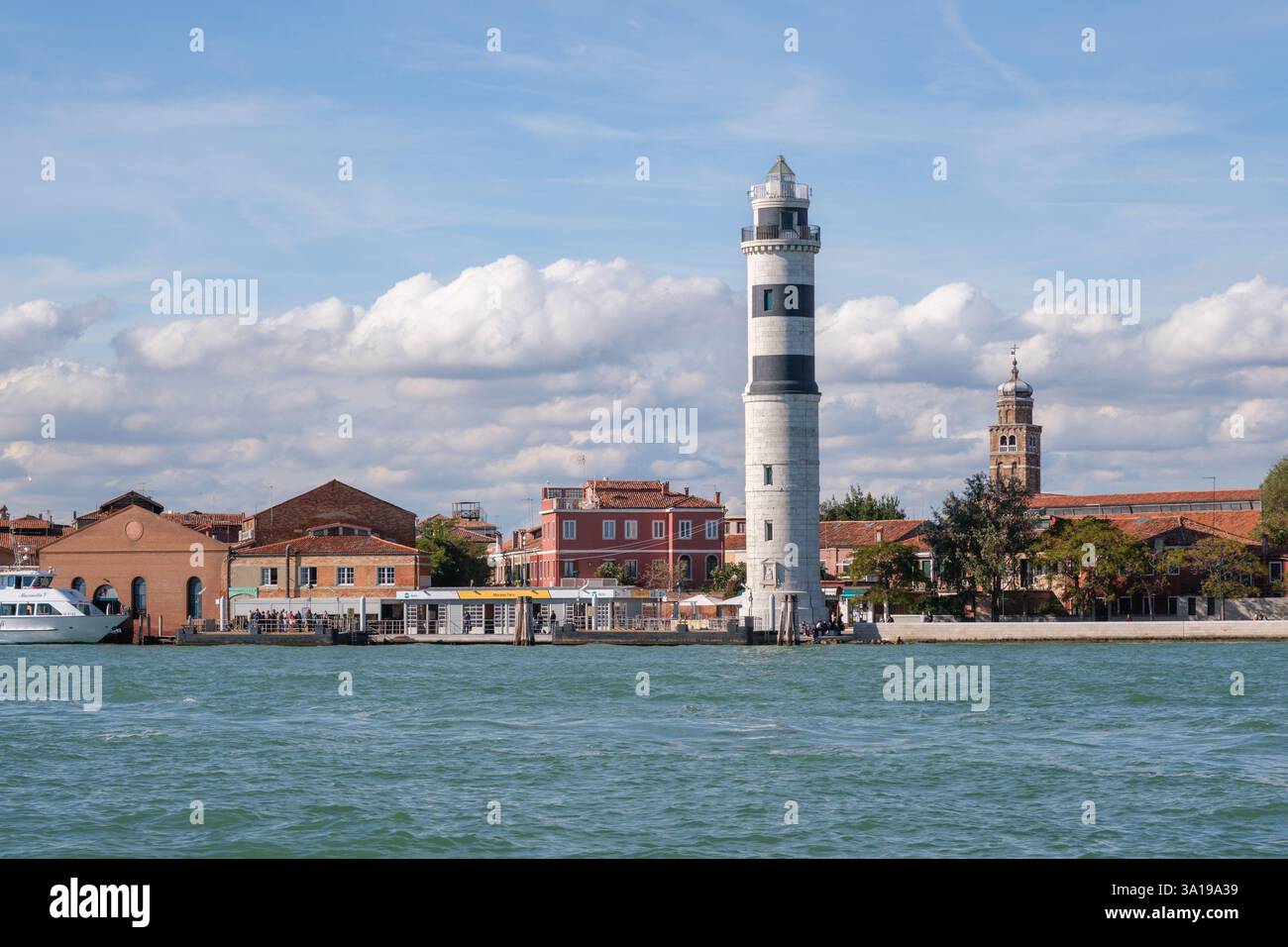 Murano, Italien - 12. Oktober 2024: Blick auf den Leuchtturm von Murano und die farbenfrohen Gebäude von der Lagune Stockfoto