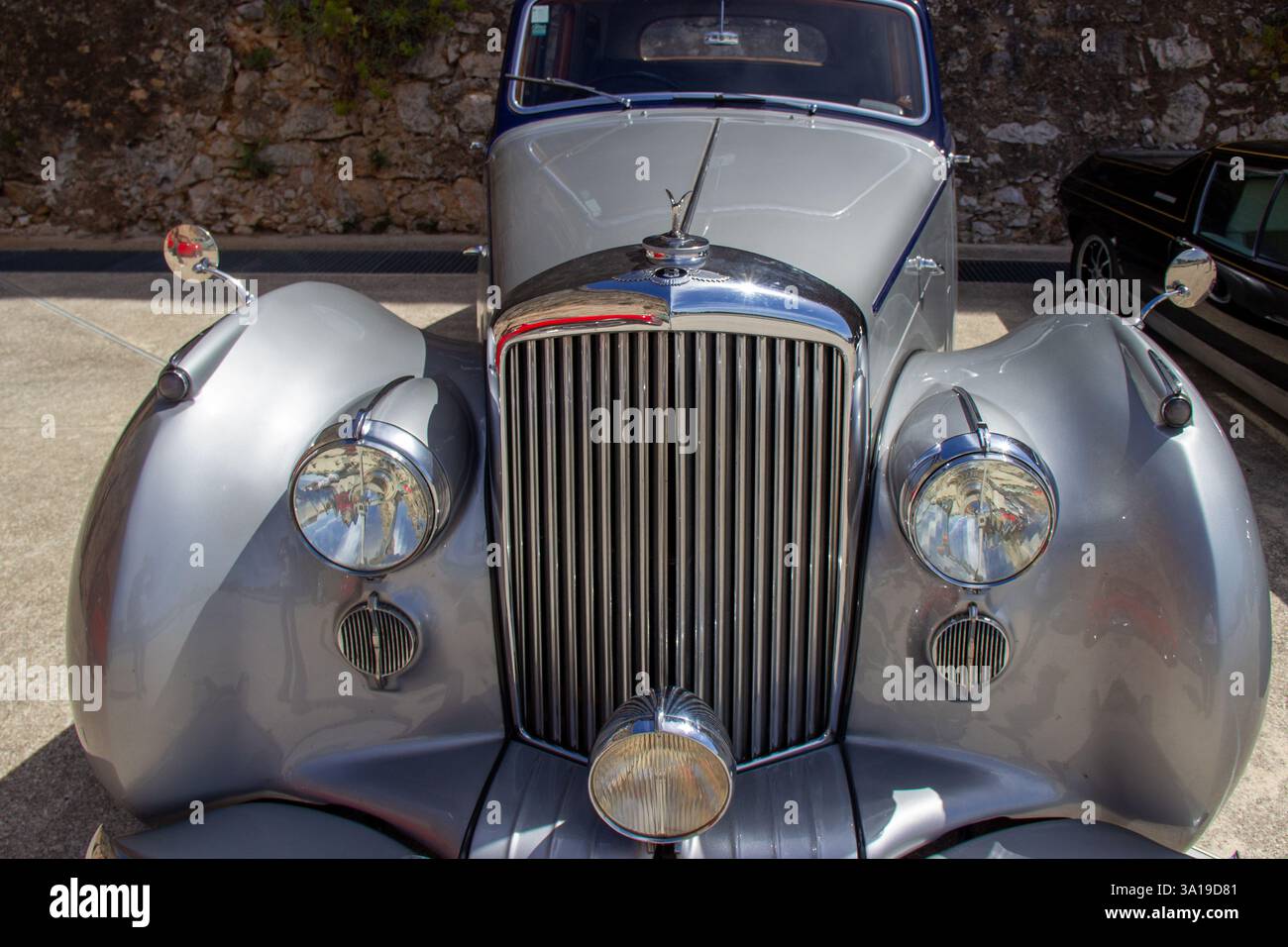Polierter Chromgrill und Scheinwerfer eines bentley Mark VI Oldtimers, der in der Nähe einer Steinmauer geparkt ist Stockfoto