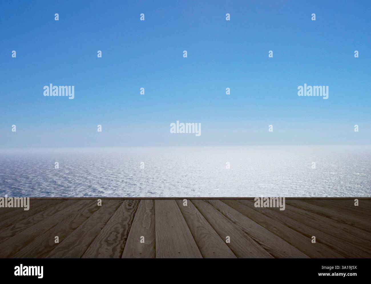 Dunkler Holzsteg am Meer mit einem endlosen Blick auf das Wasser und den blauen Himmel in der Ferne Stockfoto