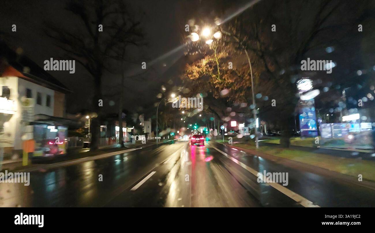 Blick auf den Stadtverkehr durch die Windschutzscheibe bei Regen und Nacht Stockfoto